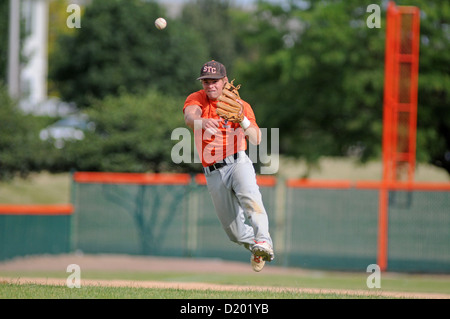 Baseball shortstop throws ball to first base high school game. USA. Stock Photo