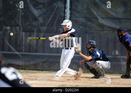 Baseball Hitter swings at ball high school game Stock Photo