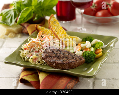 Steak and scampi shrimp past served with mixed vegetables Stock Photo