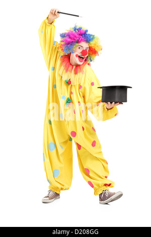 Full length portrait of a circus clown performing a magic trick isolated on white background Stock Photo