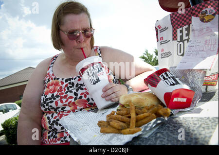 Aug. 2, 2012 - Marietta, GA - Overweight middle-aged woman eats high-fat lunch of cheeseburger, friends and soft drink at fast food restaurant near Atlanta. (Credit Image: © Robin Nelson/ZUMAPRESS.com) Stock Photo