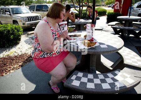 Aug. 2, 2012 - Marietta, GA - Overweight middle-aged woman eats high-fat lunch of cheeseburger, friends and soft drink at fast food restaurant near Atlanta. (Credit Image: © Robin Nelson/ZUMAPRESS.com) Stock Photo