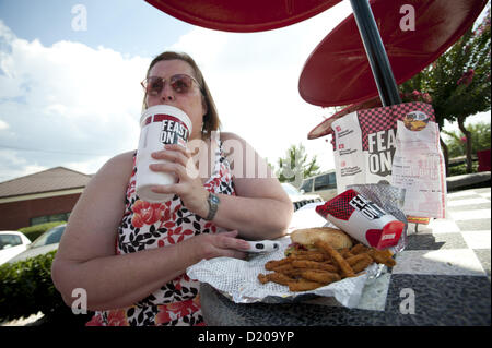 Aug. 2, 2012 - Marietta, GA - Overweight middle-aged woman eats high-fat lunch of cheeseburger, friends and soft drink at fast food restaurant near Atlanta. (Credit Image: © Robin Nelson/ZUMAPRESS.com) Stock Photo