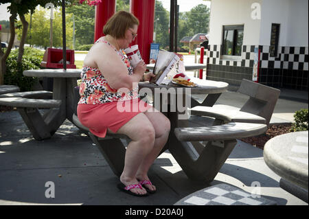 Aug. 2, 2012 - Marietta, GA - Overweight middle-aged woman eats high-fat lunch of cheeseburger, friends and soft drink at fast food restaurant near Atlanta. (Credit Image: © Robin Nelson/ZUMAPRESS.com) Stock Photo