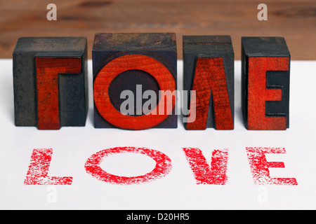 The word LOVE printed on white paper with old wooden letterpress blocks. Stock Photo