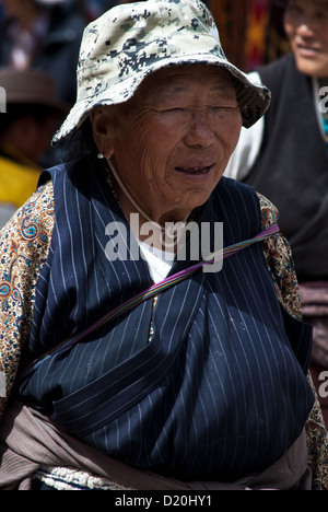 Older Tibetan woman pilgrim on Barkhor street, walking around Jokhang monastery, old town Lhasa, Tibet Stock Photo