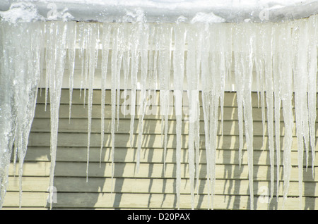 Icecicles hanging off of roof in winter Stock Photo