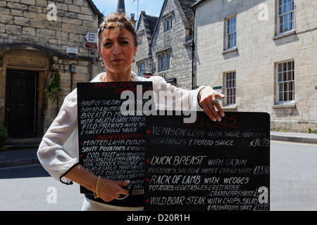 Woman showing the menu of the The Royal Oak Pub, Painswick, Gloucestershire, Cotswolds, England, Great Britain, Europe Stock Photo