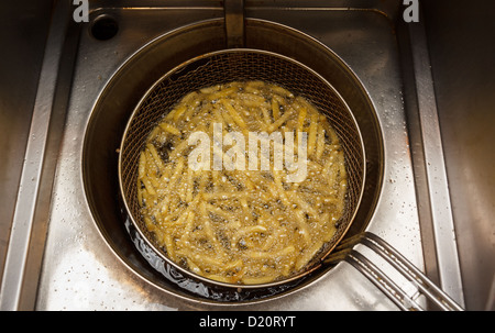 French fries in hot deep fryer at snack bar Stock Photo
