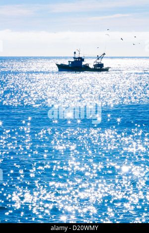 A fishing boat on the blue sea Stock Photo