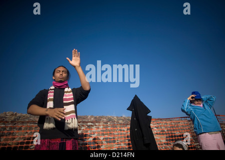 A man open his arms as he prays on the top of the Pyramid of the Sun in the archaeological site of Teotihuacan, Mexico Stock Photo