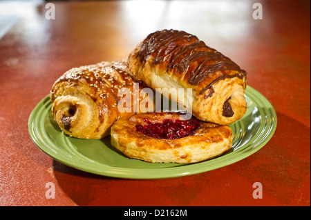 Mixed pastries on a green plate in a bakery Stock Photo