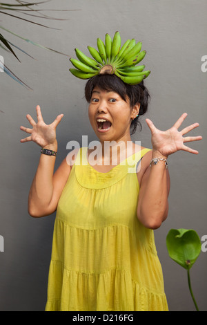 Happy and healthy woman with banana crown on her head Stock Photo