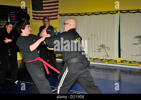 Hapkido Black Belt Master and Red Belt combatants practicing their art at a Martial Arts school. Stock Photo