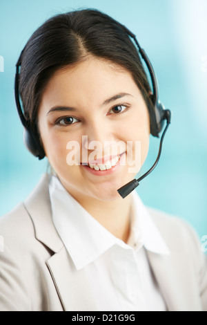 Vertical portrait of a smiling helpdesk lady being ready to consult the client Stock Photo