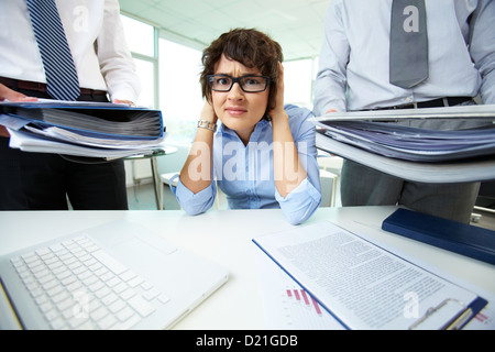 Office lady being scared because of too much paperwork to do Stock Photo