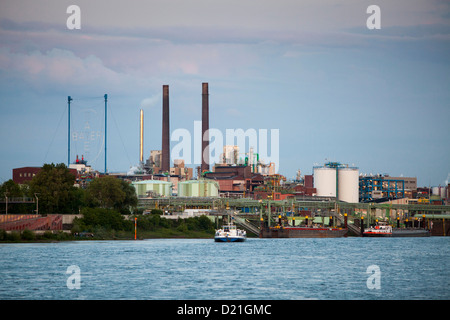 Rhine river and Bayer chemical and pharmaceutical company factory chimneys at dusk, Leverkusen, North Rhine-Westphalia, Germany, Stock Photo