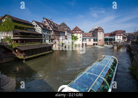 Restaurant Au Pont St. Martin and half-timbered houses and sightseeing boat on canal in La Petite France district, Strasbourg, A Stock Photo