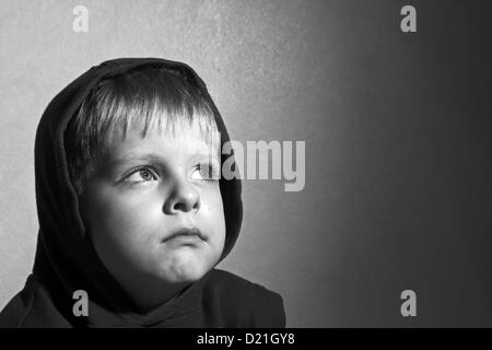 black and white photo of sad boy in the hood Stock Photo