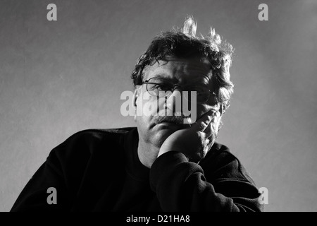 sad man sits, his head in his hand Stock Photo