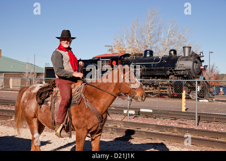 cowboy on his horse and the historic steam railway locomotive Grand Canyon Railway in Kingman, Arizona, USA Stock Photo