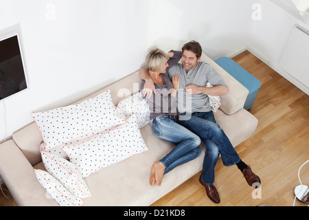 Germany, Bavaria, Munich, Mature couple relaxing on sofa, smiling Stock Photo