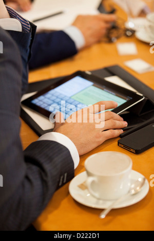 Man taking notes on a tablet during a business meeting Stock Photo