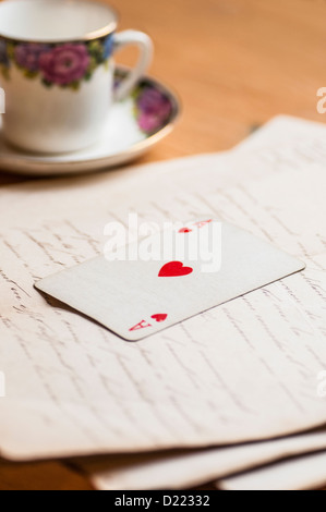 Ace of hearts playing card over old letters Stock Photo