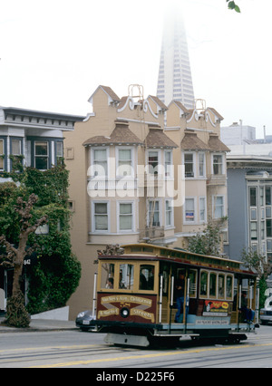 california street cable car heads up California street with transamerica pyramid in background Stock Photo