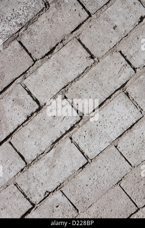 An angled gray concrete brick wall forms an abstract collection of lines and shapes in Cotacachi, Ecuador Stock Photo