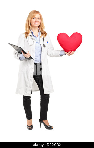 Full length portrait of a female doctor holding a red heart isolated on white background Stock Photo