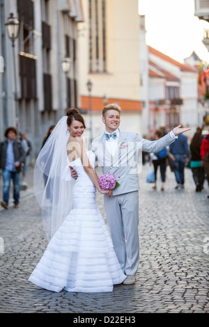 Young couple posing on their wedding day in the street Stock Photo