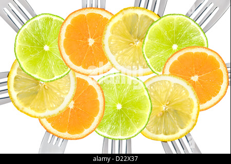 many slices of mixed citrus fruit on forks forming a repeat pattern orange lime and lemon Stock Photo