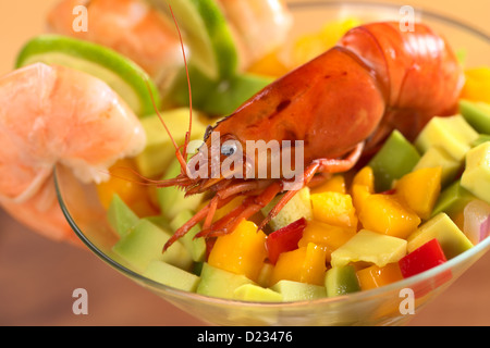 Fresh cooked shrimp on a mix of raw avocado, mango, red bell pepper and red onions in a cocktail glass Stock Photo