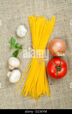 Bundle of spaghetti on burlap brown background Stock Photo