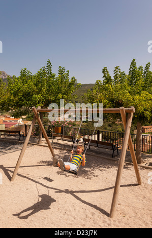 A boy playing on a swing in the old village of Pratdip , Costa Dorada , Spain Stock Photo