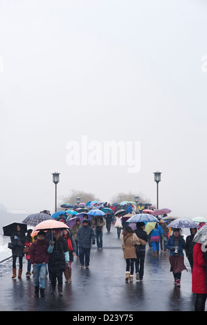 Crowds of tourists cross Broken Bridge during a snowy winter's day, West Lake, Hangzhou Stock Photo