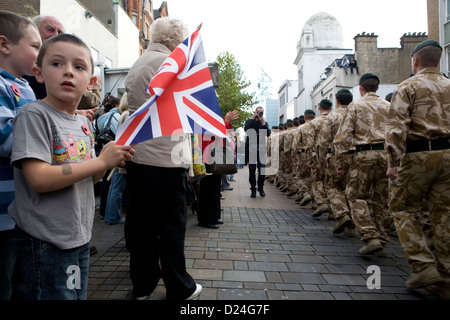 A child waving a national flag at a welcome home parade for British soldiers returning from Afghanistan. Stock Photo