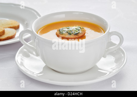 Soup made of roasted-pumpkin, parsnip, potatoes, stock and wine in a white bowl. Stock Photo
