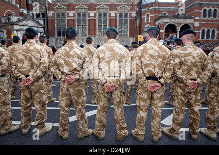 The backs of a row of British soldiers in desert camouflage. Stock Photo