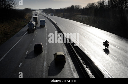 SILHOUETTED TRAFFIC WITH MOTORCYCLIST ON THE M6 MOTORWAY NEAR STAFFORD RE MOTORISTS CARS TRANSPORT LINKS COMMUTING BIKERS UK Stock Photo