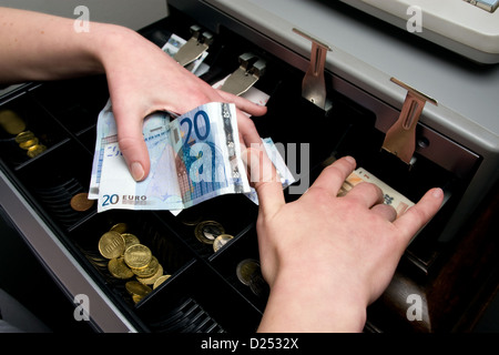 Berlin, Germany, a sales girl takes 20 Euro notes from the till Stock Photo