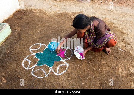 Indian girl making a Rangoli festival design outside her home in the street during the sankranthi festival. Andhra Pradesh, India Stock Photo