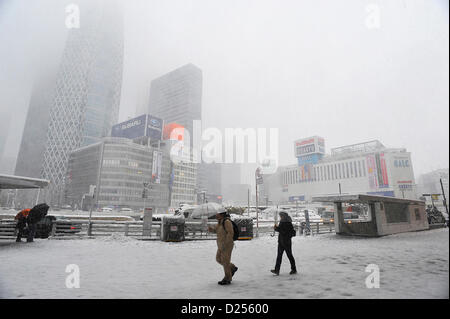 Tokyo, Japan. 14th January 2013.  People walked in the heavy snow in Shijuku, Tokyo, Japan on January 14, 2013. It was the first snow in this winter in Tokyo area. (Photo by Koichiro Suzuki/AFLO) Stock Photo