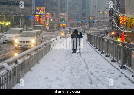 Tokyo, Japan. 14th January 2013.  A woman walked with a bicycle in the heavy snow in Shijuku, Tokyo, Japan on January 14, 2013. It was the first snow in this winter in Tokyo area. (Photo by Koichiro Suzuki/AFLO) Stock Photo