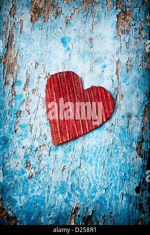 Red coconut husk bark heart shape on an old tattered blue painted door. India Stock Photo