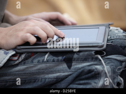 Hands of teen in jeans with tablet computer Stock Photo
