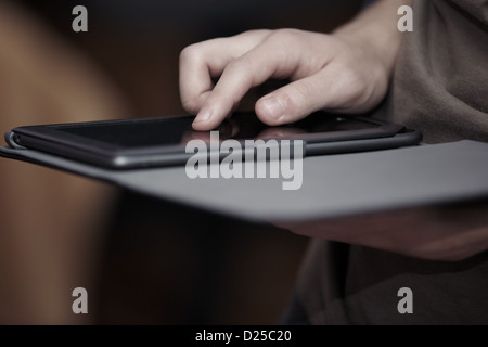 Hands of person using black tablet computer Stock Photo