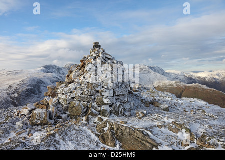 The Summit Cairn of Pike of Blisco in Winter with The Crinkle Crags and Bow Fell Behind Lake District Cumbria UK Stock Photo
