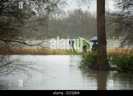 fisherman on banks of swoolen river waveney Stock Photo